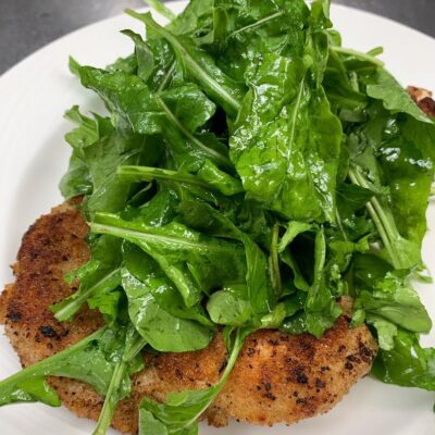 Breaded veal chop Milanese with arugula