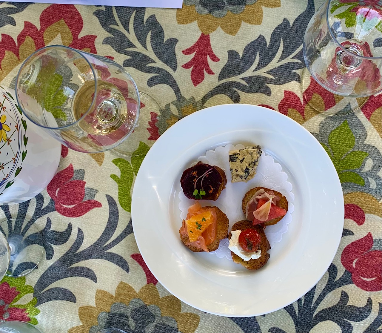 decorative tablecloth with appetizers and wine glasses