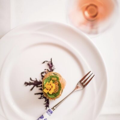Aerial view of a single smoked salmon appetizer with a glass of wine