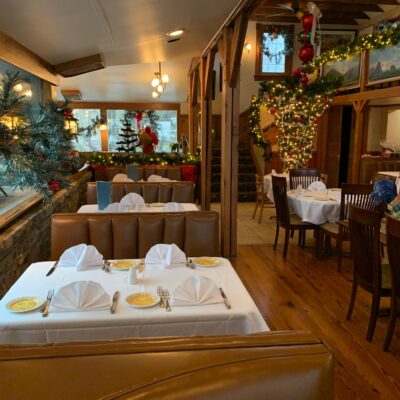 Main dining room decorated with Christmas trees, lights, and garland