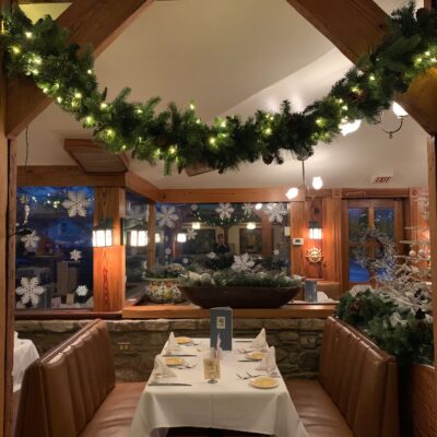 Set table and booth decorated with garland and snowflakes