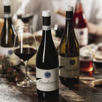 Wine bottles on table with fruit and appetizers