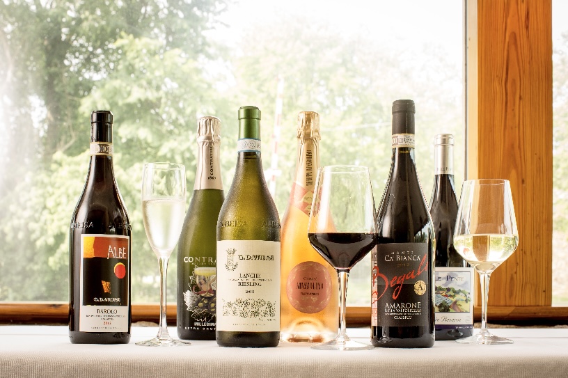 Bottles and glasses of sparkling, white, and red wine displayed on a table