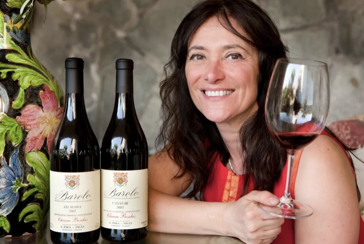 Chiara Boschis with glass of wine and bottles