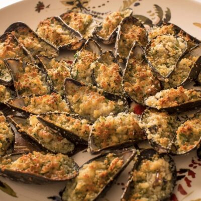 Baked mussels topped with breadcrumbs, garlic, and herbs