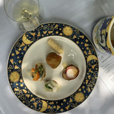 An assortment of small appetizers with a glass of white wine