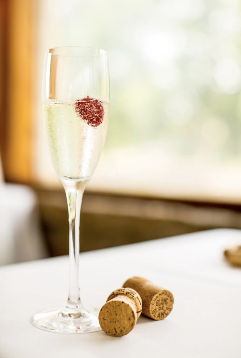 Glass of sparkling wine with fruit and corks